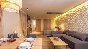 Un salon moderne avec un canapé, une table à manger dressée pour deux personnes et un mur à texture.