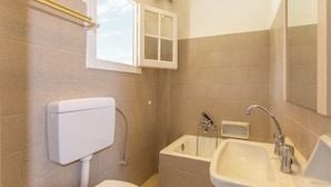 Ein Badezimmer mit Toilette, Waschbecken und Fenster.