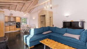 Una sala de estar moderna con un sofá seccional azul, una mesa de centro de madera y una chimenea de piedra.