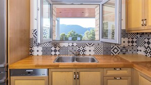 Una cocina con encimera de madera, un lavabo doble y lavavajillas.