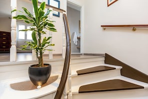 Un escalier avec un pot de fleurs placé sur la plateforme.