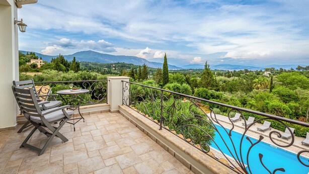Ein Balkon mit Pool, Gartenmöbeln und Blick auf die Landschaft.