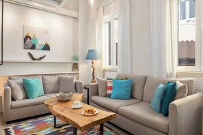 A living room with a sofa, coffee table, and artwork on the wall. - Studio No3, CasaNova, Corfu Old town center (Corfu)