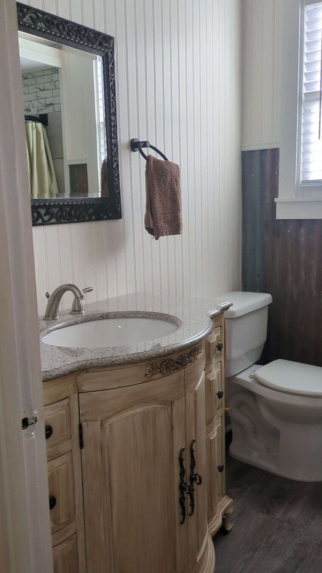 A bathroom with a vanity, sink, mirror, towel rack, and toilet.