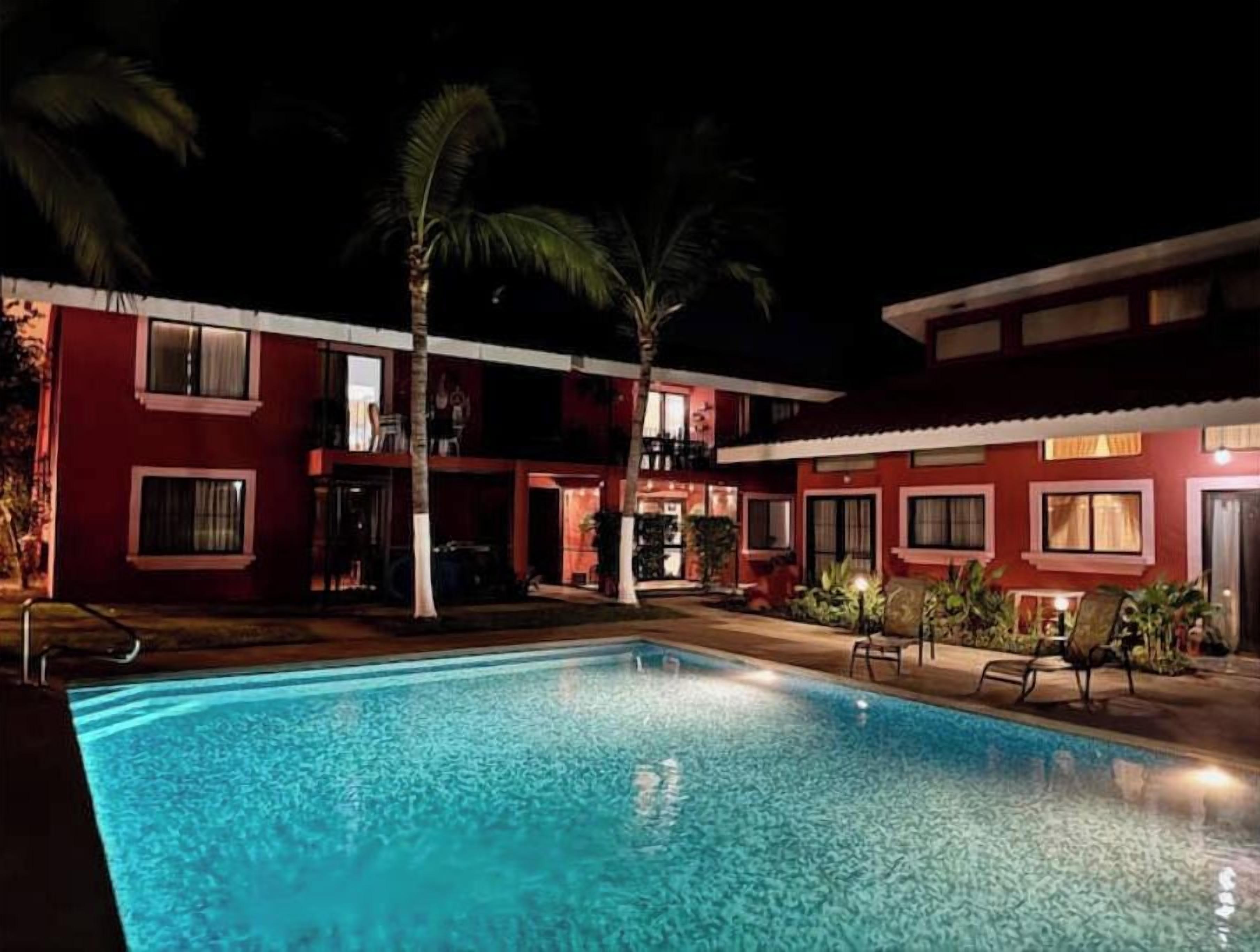 A swimming pool with a red building in the background.
