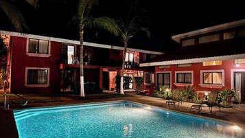 A swimming pool with a red building in the background.