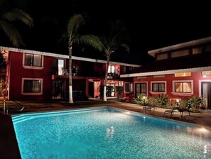 Une piscine avec un bâtiment rouge en arrière-plan.