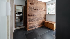 Un intérieur moderne avec un mur d’accent en bois, un banc et un grand miroir.