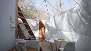 A tented accommodation with a wooden desk, a kettle, and a table with chairs. - Refugio Atreyu (Lo Barnechea)