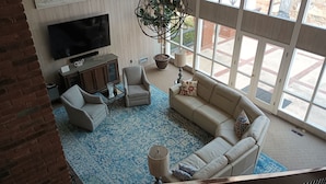 A spacious living room with a large TV, comfortable seating, a potted plant, and a view through large windows. - Beautiful and Scenic 6 bedrooms and 6 bathrooms large pool a hot tub 7000sqft (Prospect)