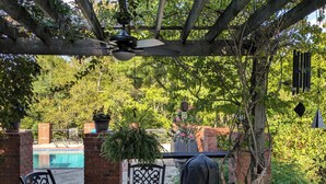 A patio with a table and chairs, a pergola overhead, and a view of a pool and greenery. - Beautiful and Scenic 6 bedrooms and 6 bathrooms large pool a hot tub 7000sqft (Prospect)