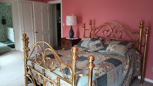 Un dormitorio con cama, mesita de noche, lámpara y puerta.