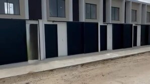 Een modern gebouw met meerdere wooneenheden, elk voorzien van grote ramen en een plat dak.