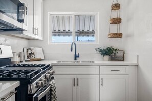 Une cuisine équipée d’une cuisinière, d’un évier et de placards.