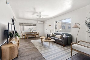 Una sala moderna con sofá, mesa de centro y comedor.