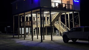 A two-story building with a balcony and a staircase. - Camp Conex a Shipping Container in Shell Beach, LA (St. Bernard Parish)
