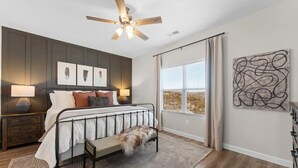 A bedroom with a bed, bedside tables, a ceiling fan, artwork, and a window with curtains. - Branson Beauty! 4brm condo! Central Location (Branson)