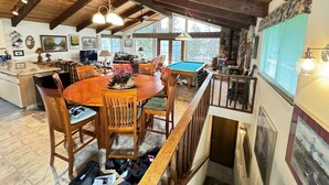 A spacious living area with a pool table, wooden furniture, and a dining table. - Lakeview, Pool Table, Near Marina, Sleeps 10 (Lakehead)