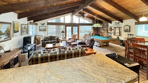 A spacious living area with a pool table, a sofa, and a dining table. - Lakeview, Pool Table, Near Marina, Sleeps 10 (Lakehead)