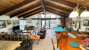 A cozy cabin interior with a wooden ceiling, a pool table, a sofa, and a television. - Lakeview, Pool Table, Near Marina, Sleeps 10 (Lakehead)