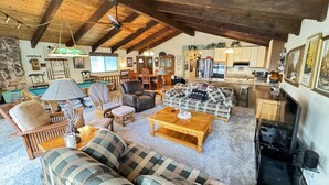 A cozy living room with a fireplace, a pool table, and a dining area. - Lakeview, Pool Table, Near Marina, Sleeps 10 (Lakehead)