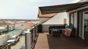 Une terrasse sur le toit avec une piscine, des espaces de détente en plein air et une vue sur la ville.