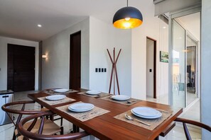 Enjoy meals in this dining area with a rectangular table and four chairs, illuminated by a pendant light fixture.