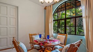 Comedor con una mesa redonda dispuesta para cuatro personas, rodeado de sillas de madera con asientos acolchados.