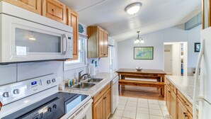 Une cuisine avec des meubles en bois, un four à micro-ondes, une cuisinière et un évier.