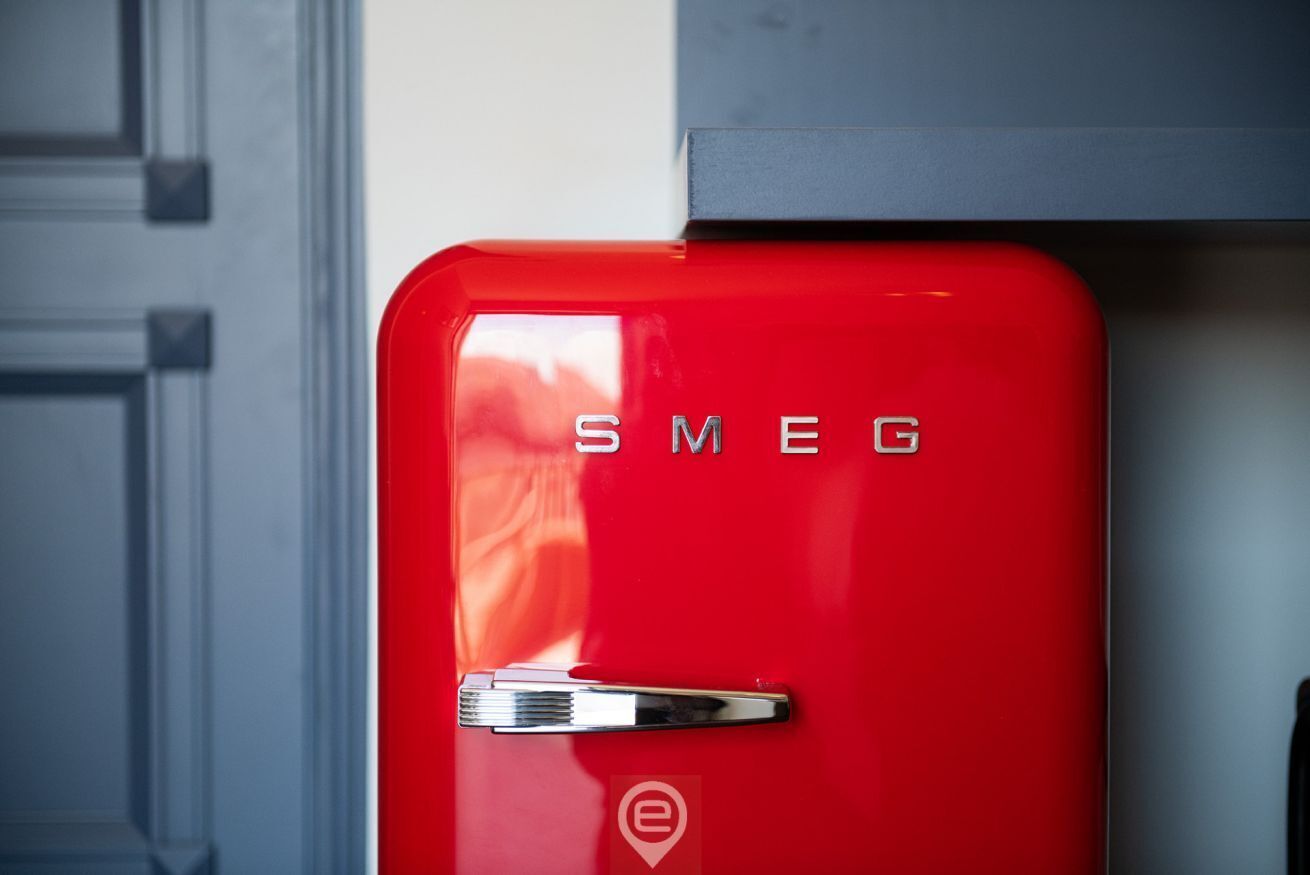 A red vintage-style refrigerator with the brand name "SMEG" on the front.