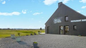 Een gebouw met een bord waarop staat: GOLF UTAH BEACH NORMANDIE RESTAURANT BAR.