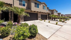 A row of modern two-story houses with attached garages, surrounded by landscaped gardens and palm trees. - Southern Utah charm. Close to St George and National Parks (Washington)