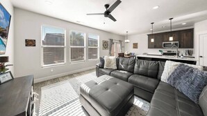 A modern living room with a sectional sofa, a dining area, and a kitchen. - Southern Utah charm. Close to St George and National Parks (Washington)