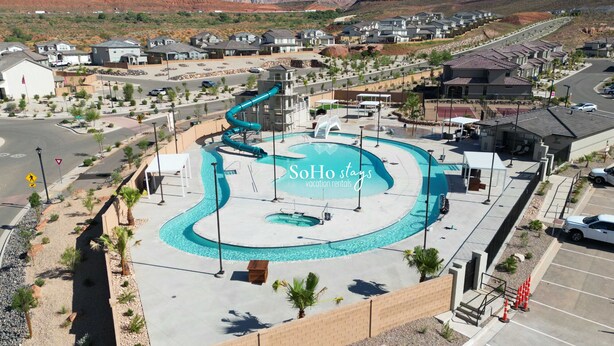 Un resort con piscina, tobogán de agua y vistas a montañas.