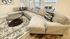 Un soggiorno moderno con un divano componibile, un tavolino da caffè e un tappeto decorato.