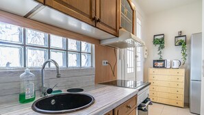 A kitchen with wooden cabinets, a sink, a stove, and a microwave.