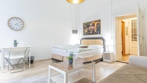 A modern bedroom with a bed, bedside table, and a small desk with a chair. - Chic Apartment Suitable for Longstays in Lockdown (Vienna)