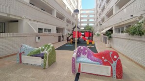 A multi-level atrium with a children's play area, including a slide and climbing structure.