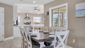 A modern kitchen with a dining area, featuring a large window, ceiling fan, and a view of the outdoors. - 618 via Tunis (Punta Gorda)
