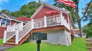 A two-story house with a red exterior, white railings, and a red roof.