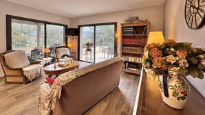 Un salón amplio con un sofá grande, una estantería y un jarrón decorativo.