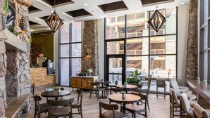 Un restaurante con paredes de piedra, amplias ventanas y muebles de madera.