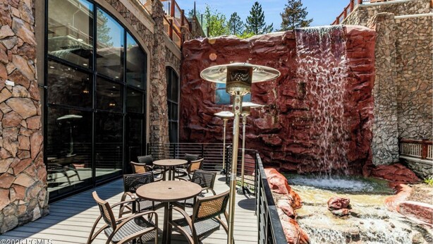 Un patio con mobiliario exterior y una cascada.