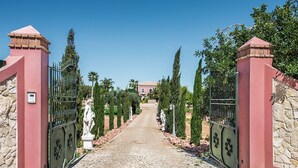 A cobblestone pathway leading to a gated entrance with stone walls and metal gates. - Quinta Valente VIP Properties by Interhome (Silves)