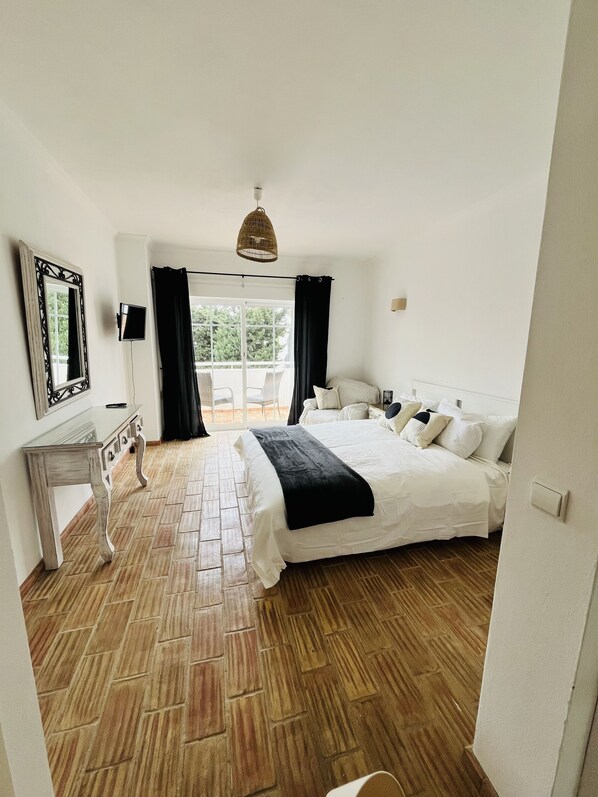 A bedroom with a bed, a dresser, a mirror, and a television. - Casa Da Praia right on magical Luz beach
(Luz)