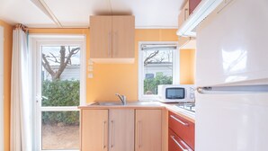 A compact kitchen with a microwave, sink, and cabinets. - Holiday Home 'BW 2018 IV' with Mountain View, Wi-Fi and Air Conditioning (Bárig)