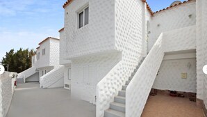 A white building with a staircase leading to a door, a small window, and a tiled floor. - Vacation Apartment 'Casa Weimar' with Private Terrace and Wi-Fi (Costa Calma)