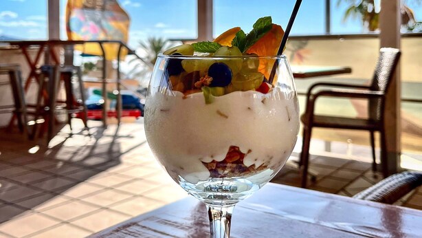 A dessert in a glass on a table with a view of the sky and palm trees. - Vacation Apartment 'Casa Weimar' with Private Terrace and Wi-Fi (Costa Calma)