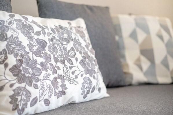 A sofa with patterned pillows, a geometric pillow, and a plain pillow. - Vacation Apartment 'Casa Weimar' with Private Terrace and Wi-Fi (Costa Calma)