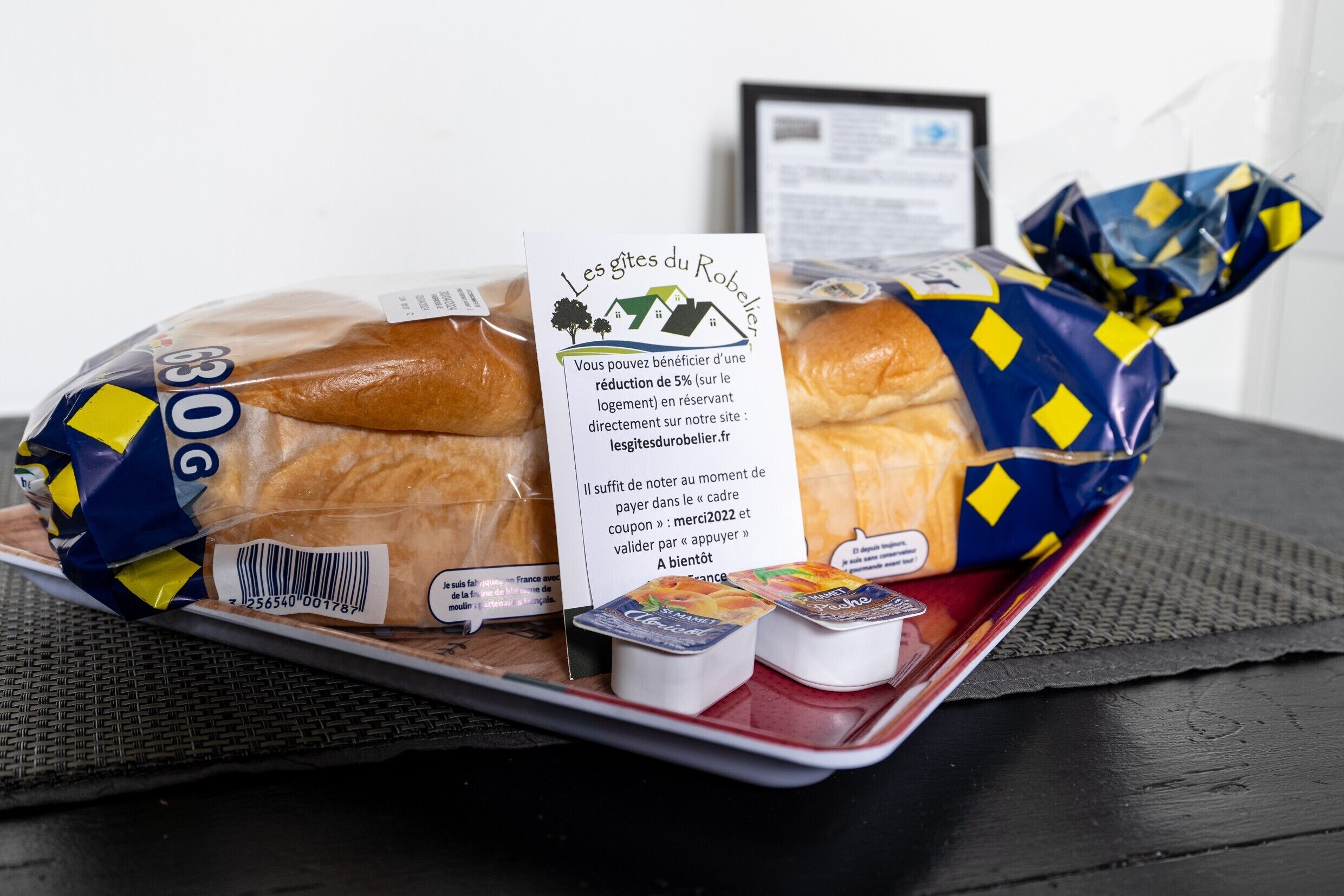 A loaf of bread with a discount sign, a tray, and a small container of yogurt.